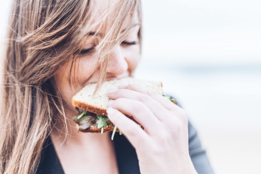 サンドイッチで食物繊維をとろうと意識している女性のイメージ